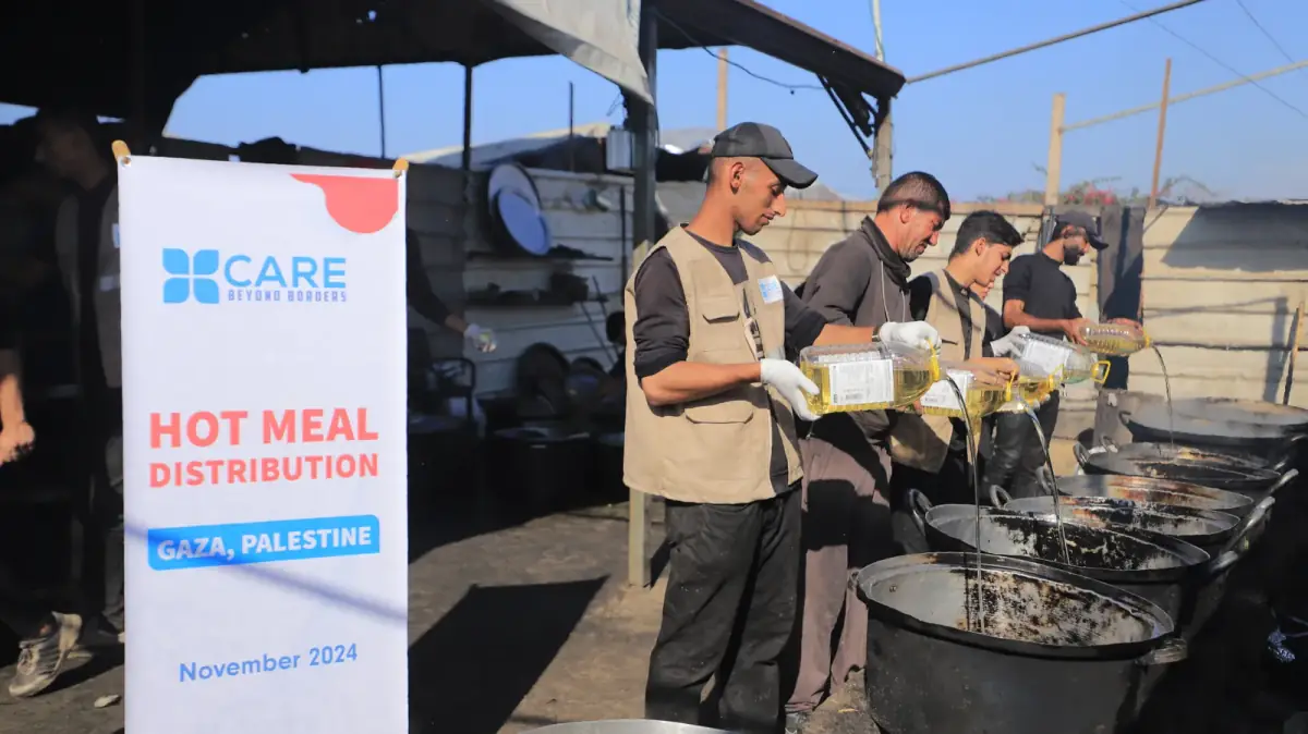 CBB volunteers cooking hot meals in large pots at a meal distribution site in Gaza