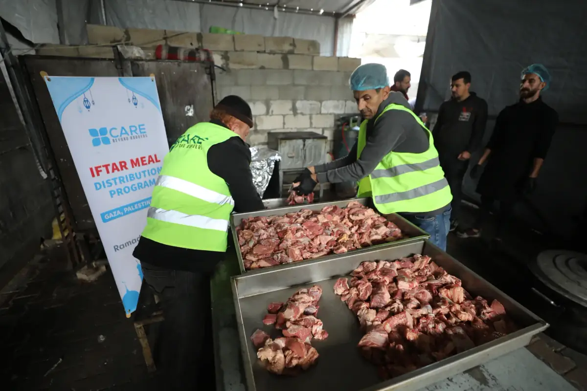 CBB volunteers preparing trays of meat for an iftar meal distribution in Gaza